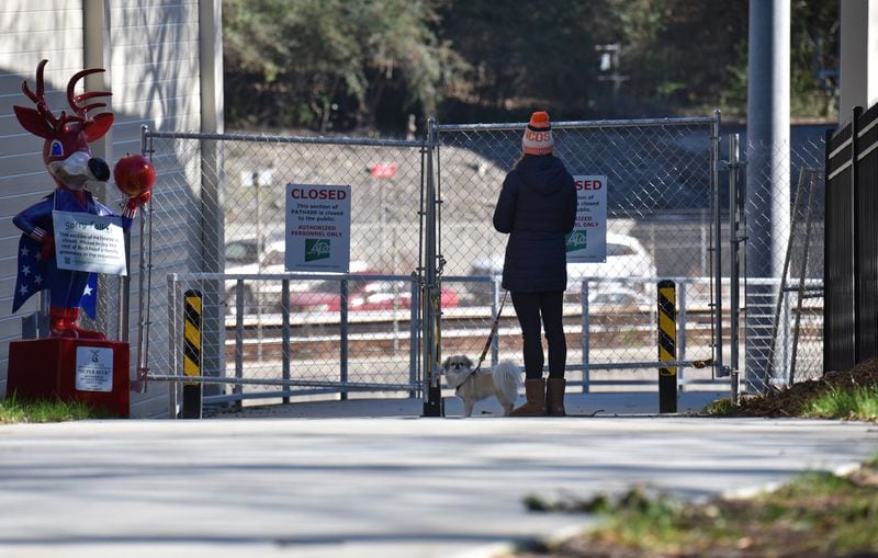 A resident stops at a new segment of PATH400, which is nearly complete but was still closed on Dec. 19, 2019. The PATH400 through Buckhead is broken into two pieces, but this new section slated to open early next year will connect them, completing the ride through one of the busiest parts of Atlanta. New links like this are being forged in broken paths across metro Atlanta to create a regional network that could serve as an alternative to roads. HYOSUB SHIN / HYOSUB.SHIN@AJC.COM