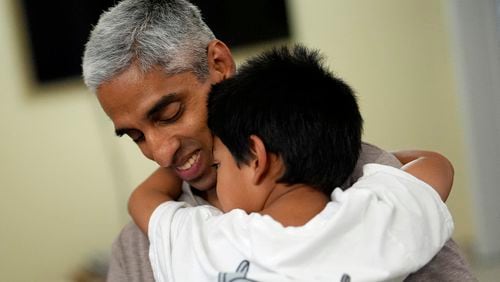 Surgeon General Vivek Murthy hugs one of his children during a visit to his parents' home, Tuesday, July 16, 2024, near Miami. (Rebecca Blackwell/AP)