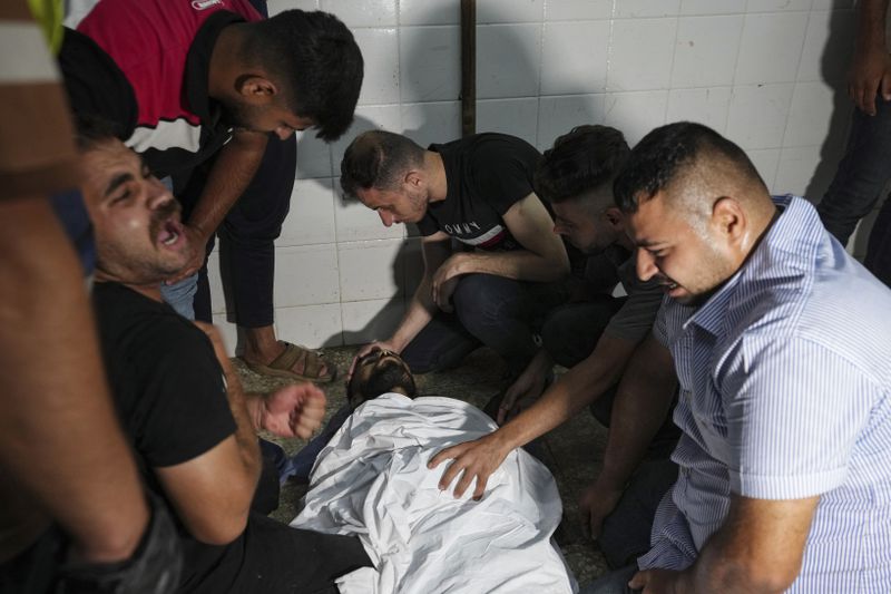 Palestinians mourn their relatives killed in the Israeli bombardment on a residential building owned by the Daloul family, at the morgue of al-Aqsa Martyrs hospital in Deir al-Balah, central Gaza Strip, Thursday, June 6, 2024. (AP Photo/Abdel Kareem Hana)
