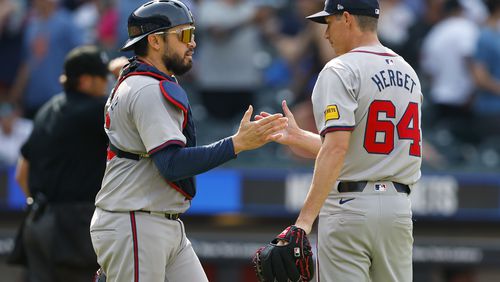 Atlanta Braves catcher Travis d'Arnaud, left, and relief pitcher Jimmy Herget (64) shake hands after defeating the New York Mets in a baseball game, Sunday, July 28, 2024, in New York. (AP Photo/Rich Schultz)