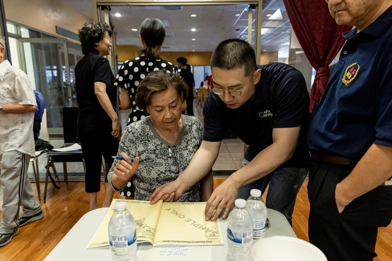 Cizhuo Cheng, field manager for One APIA Nevada, reviews a sample ballot with Sue Deng during the annual Dragon Boat Festival in Las Vegas on Wednesday, June 5, 2024. (Photo by Christopher Lomahquahu/News21)