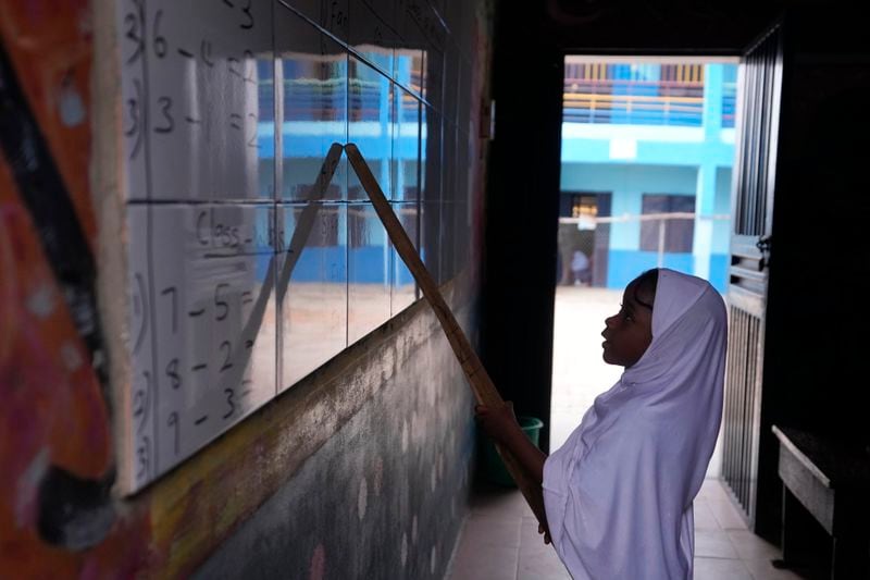 A student of Lorat Nursery and Primary School answers a question on a white board in Ibadan, Nigeria, Tuesday, May 28, 2024. The lack of reliable electricity severely affects education and businesses in Nigeria. (AP Photo/Sunday Alamba)
