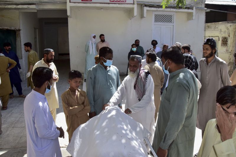 Relatives stand around a body of a passenger, who was killed by gunmen at a highway in Musakhail, and wait for transportation at a hospital, in Quetta, Pakistan, Monday, Aug. 26, 2024. (AP Photo/Arshad Butt)