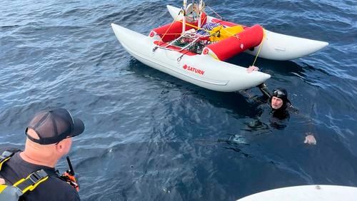 In this image provided by Jonathan Boeve, Jim Dreyer, right, talks to his support team in Lake Michigan, Thursday, Aug. 8, 2024, on the third day of his attempt to swim from Michigan to Wisconsin. (Jonathan Boeve via AP)