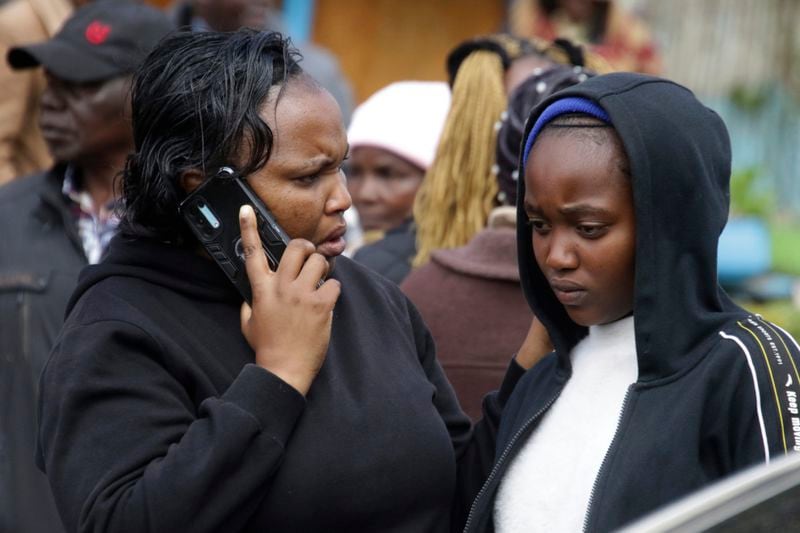 Distressed parents and relatives stand near a burned-out dormitory, following a fire at the Hillside Endarasha Primary in Nyeri, Kenya Friday, Sept. 6, 2024. (AP Photo)