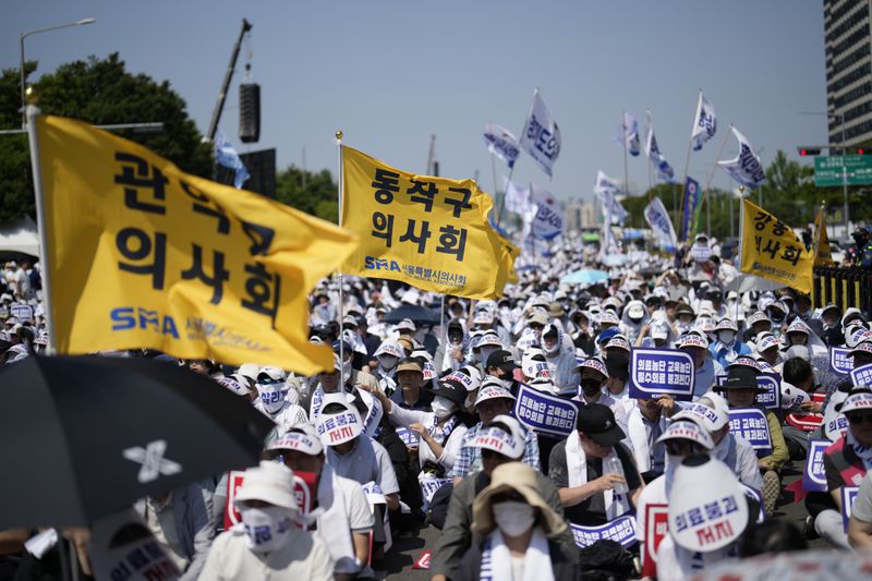 Members of The Korea Medical Association attend at a rally against the government's medical policy in Seoul, South Korea, Tuesday, June 18, 2024. South Korean officials issued return-to-work orders for doctors participating in a one-day walkout Tuesday as part of a protracted strike against government plans to boost medical school admissions, starting next year. (AP Photo/Lee Jin-man)