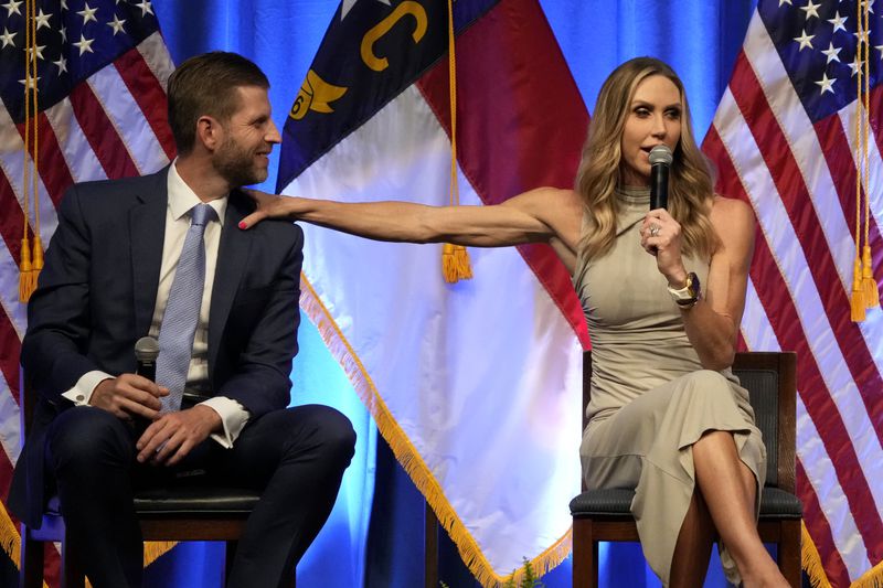Lara Trump reaches out to her husband, Eric Trump, as she speaks at the North Carolina GOP convention in Greensboro, N.C., Friday, May 24, 2024. (AP Photo/Chuck Burton)