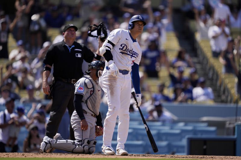 Los Angeles Dodgers' Shohei Ohtani, right, watches as his ball goes out for a solo home run as Cleveland Guardians catcher Bo Naylor, center, and home plate umpire Dan Bellino watch as well during the fifth inning of a baseball game, Sunday, Sept. 8, 2024, in Los Angeles. (AP Photo/Mark J. Terrill)