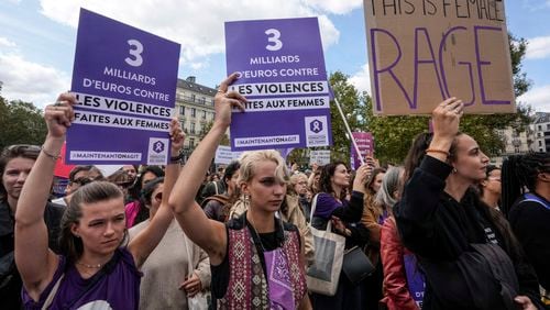 People take part in a gathering in support of 71-year-old Gisele Pelicot who was allegedly drugged by her ex-husband and raped by dozens of men while unconscious, Saturday, Sept. 14, 2024 in Paris. Placards left read, "3 billion euros to combat violence against women." (AP Photo/Michel Euler)