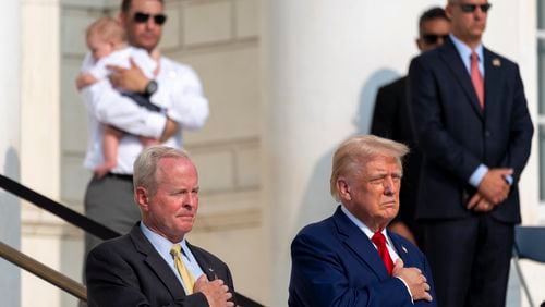 Bob Quackenbush, left, deputy chief of staff for Arlington National Cemetery, and Republican presidential nominee former President Donald Trump watch the changing of the guard at the Tomb of the Unknown Solider at Arlington National Cemetery, Monday, Aug. 26, 2024, in Arlington, Va. (AP Photo/Alex Brandon)