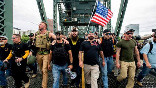 Proud Boys organizer Joseph Biggs, in green hat, was arrested in central Florida and faces charges of obstructing an official proceeding before Congress, entering a restricted area on the grounds of the U.S. Capitol and disorderly conduct. (AP Photo/Noah Berger, File)