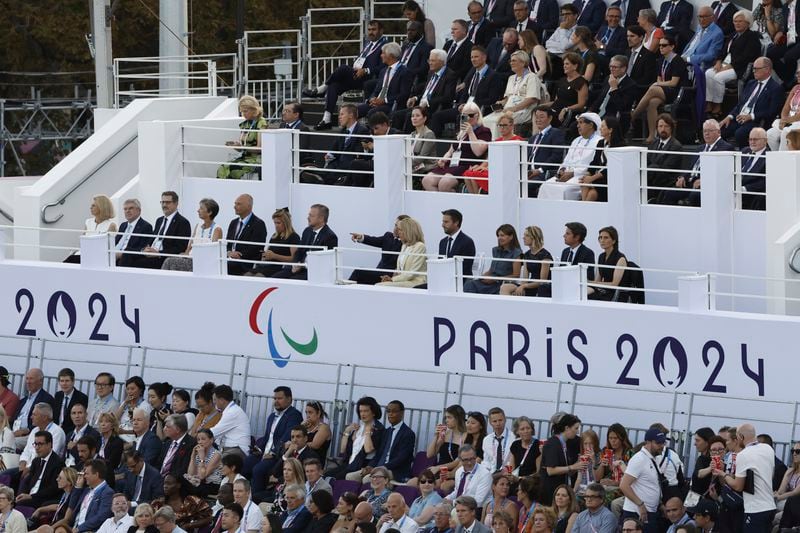 French President Emmanuel Macron points towards the stage as he sits next to his wife Brigitte while they watch the Opening Ceremony for the 2024 Paralympics, in Paris, Wednesday Aug. 28, 2024. (AP Photo/Felix Rodriguez-Scheyer)