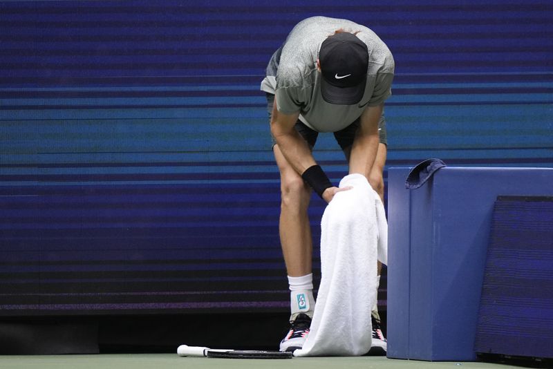 Jannik Sinner, of Italy, holds his left wrist after falling on the court in the second set against Jack Draper, of Great Britain, during the men's singles semifinal of the U.S. Open tennis championships, Friday, Sept. 6, 2024, in New York. (AP Photo/Frank Franklin II)