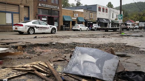 A Madison County sheriff's vehicle passes damaged buildings along Bridge Street in the aftermath of Hurricane Helene Tuesday, Oct. 1, 2024, in Hot Springs, N.C. (AP Photo/Jeff Roberson)