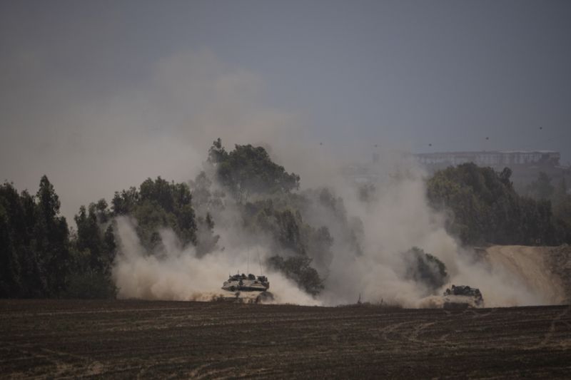 Israeli armoured vehicles move near the Israeli-Gaza border, as seen from southern Israel, Saturday, June 29, 2024. (AP Photo/Leo Correa)