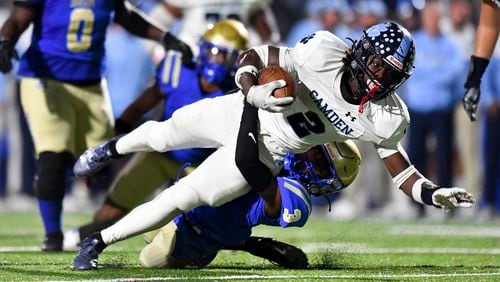 Camden County’s Ja’Marley Riddle (2) is brought down within yards of the goalline by McEachern’s Terry Wilson (3) during the first half of a playoff game against McEachern Friday, Nov. 17, 2023. (Daniel Varnado/For the AJC)