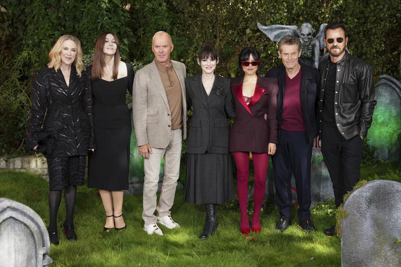 Catherine O'Hara, from left, Monica Bellucci, Michael Keaton, Winona Ryder, Jenna Ortega, Willem Dafoe and Justin Theroux pose for photographers upon arrival at the photo call for the film "Beetlejuice Beetlejuice" on Friday, Aug. 30, 2024, in London. (Photo by Scott A Garfitt/Invision/AP)