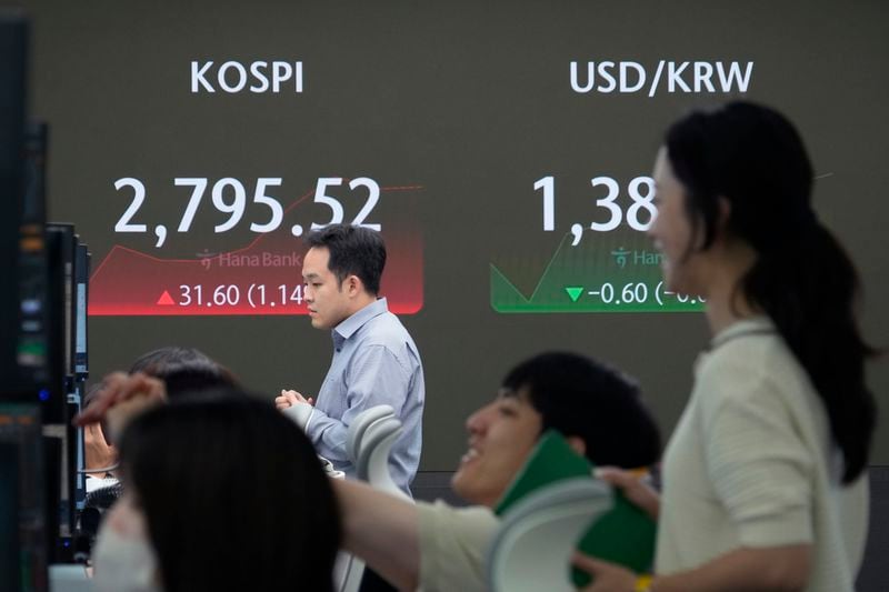 Currency traders watch monitors near the screen showing the Korea Composite Stock Price Index (KOSPI), left, and the foreign exchange rate between U.S. dollar and South Korean won at the foreign exchange dealing room of the KEB Hana Bank headquarters in Seoul, South Korea, Wednesday, June 19, 2024. (AP Photo/Ahn Young-joon)