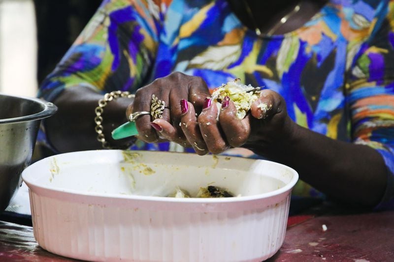 In her kitchen, with practiced hands, Chef Sallie Ann Robinson swiftly picks the sweet, tender crab meat from the legs and shells, showcasing her expertise and the efficiency honed by generations of island cooking. (Adriana Iris Boatwright for The Atlanta Journal-Constitution)