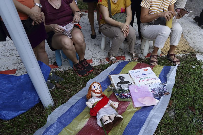 People wait for Pope Francis to arrive outside St Theresa's Home in Singapore, Friday, Sept. 13, 2024. (AP Photo/Suhaimi Abdullah)