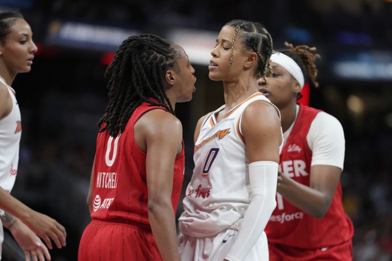 Indiana Fever's Kelsey Mitchell (0) and Phoenix Mercury's Natasha Cloud (0) have to be separated during the second half of a WNBA basketball game, Friday, Aug. 16, 2024, in Indianapolis. (AP Photo/Darron Cummings)