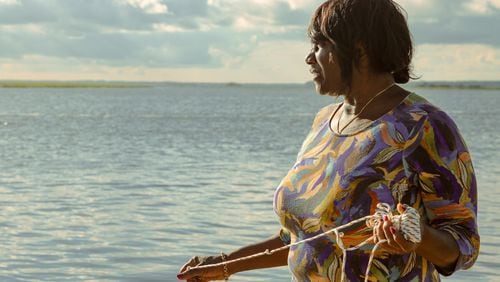 Chef Sallie Ann Robinson expertly throws her crab net into the water, blending skill with heritage as she gathers fresh crabs for her signature dish, Ol' 'Fuskie Fried Crab Rice. (Adriana Iris Boatwright for the Atlanta Journal-Constitution)