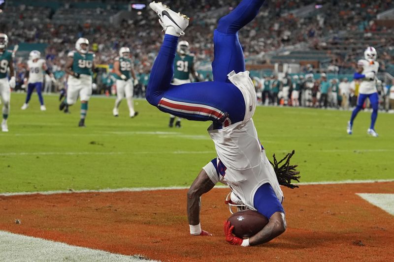 Buffalo Bills running back James Cook (4) holds onto the ball to score a touchdown during the first half of an NFL football game against the Miami Dolphins, Thursday, Sept. 12, 2024, in Miami Gardens, Fla. (AP Photo/Lynne Sladky)