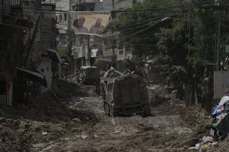 A convoy of Israeli military armored vehicles is seen during an army raid in Tulkarem, West Bank, on Tuesday, Sept. 3, 2024. (AP Photo/Majdi Mohammed)