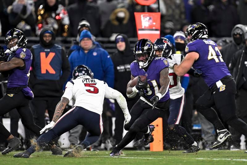 FILE - Baltimore Ravens running back Dalvin Cook runs the ball as Houston Texans safety Jalen Pitre (5) attempts to tackle him during the second half of the NFL divisional round playoff football game, Jan. 20, 2024, in Baltimore. (AP Photo/Terrance Williams, File)