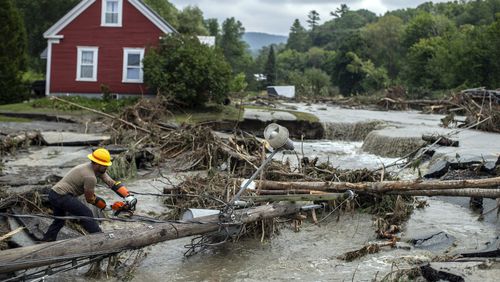 Zac Drown, of Lyndon Electric Company, clears debris amid flood damage in Lyndon, Vt., Tuesday, July 30, 2024. (AP Photo/Dmitry Belyakov)