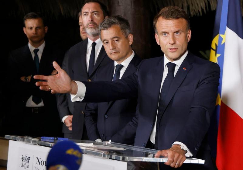 French President Emmanuel Macron, right, delivers a speech at New Caledonia's High Commissioner residency, with French Interior r Minister Gerald Darmanin, center, in Noumea, France's Pacific territory of New Caledonia Thursday May, 23, 2024. French President Emmanuel Macron pushed Thursday on a visit to riot-hit New Caledonia for the removal of protesters' barricades and said police sent in to help battle deadly unrest in the French Pacific archipelago "will stay as long as necessary," even as security services back in France focus in coming weeks on safeguarding the Paris Olympics. (Ludovic Marin, Pool via AP)