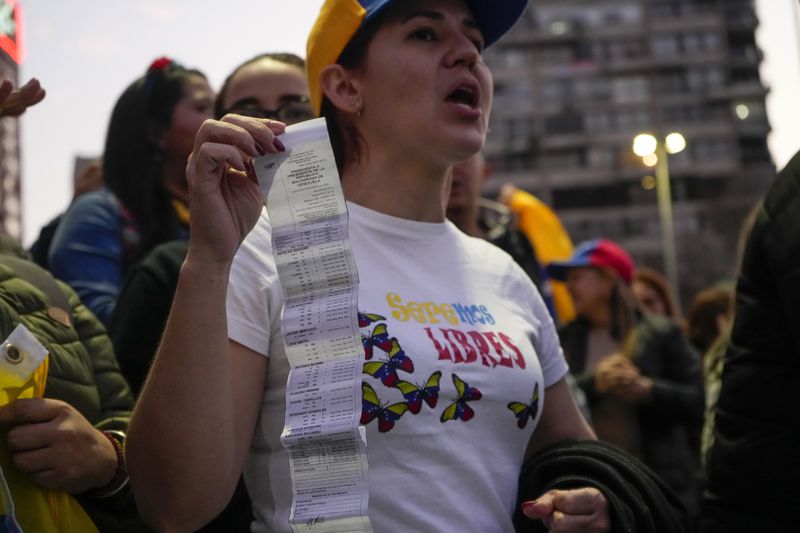 Venezuelans protest the reelection of Venezuelan President Nicolas Maduro one month after the disputed presidential vote which the opposition claims it won by a landslide, in Santiago, Chile, Wednesday, Aug. 28, 2024. (AP Photo/Esteban Felix)