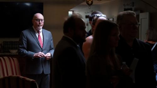 The Rev. Michael McCullar stands back as family arrives and greets each other before officiating a memorial service for Jonathan Erik Locke in Peachtree Corners on Saturday, July 27, 2024. (Ben Gray for the AJC)