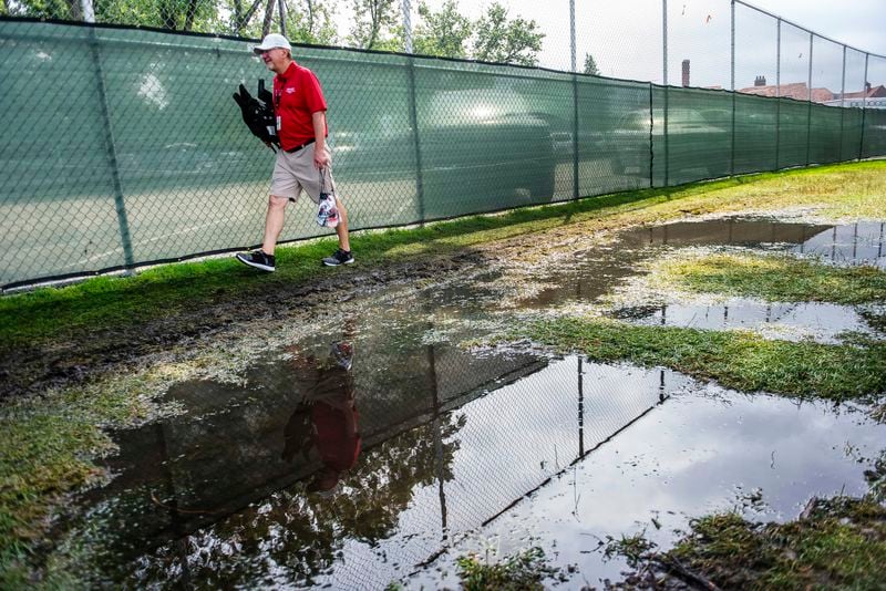 A volunteer walks past a large puddle after after heavy rains ahead of the third round of the PGA Rocket Mortgage Classic golf tournament, Saturday, June 29, 2024, at the Detroit Golf Club in Detroit. (Katy Kildee/Detroit News via AP)