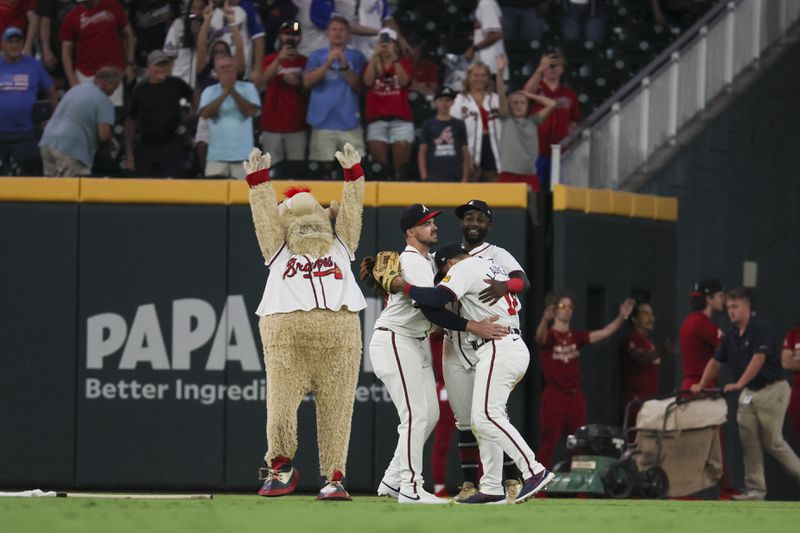 Braves outfielders celebrate the win with a little help from mascot Blooper.