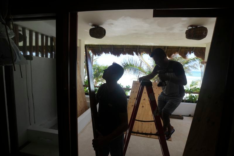 Employees board up windows of a hotel as protection in anticipation of Hurricane Beryl's arrival, in Tulum, Mexico, Thursday, July 4, 2024. (AP Photo/Fernando Llano)