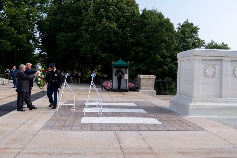 Bill Barnett, left, grandfather of Darin Taylor Hoover, and Republican presidential nominee former President Donald Trump place a wreath at the Tomb of the Unknown Solider in honor of Staff Sgt. Darin Taylor Hoover at Arlington National Cemetery, Monday, Aug. 26, 2024, in Arlington, Va. (AP Photo/Alex Brandon)