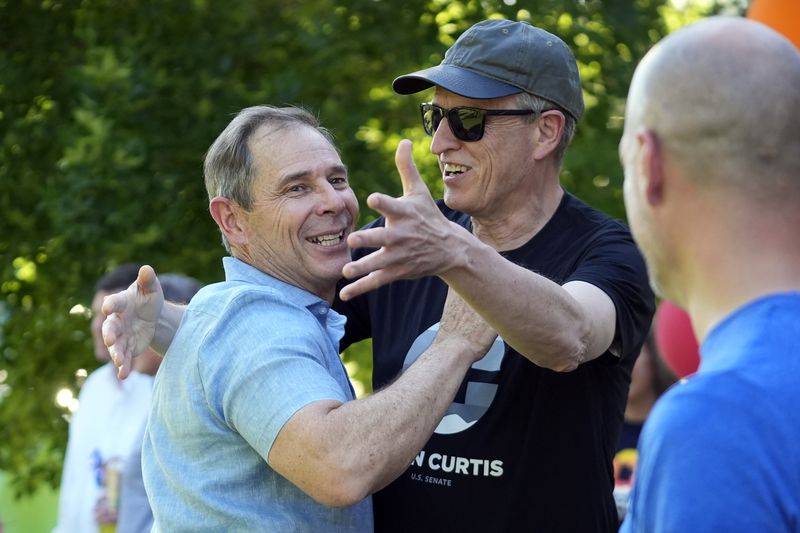 U.S. Rep. John Curtis receives a hug from Wayne Johnson during an election night party Tuesday, June 25, 2024, at a park in Provo, Utah. (AP Photo/Rick Bowmer)