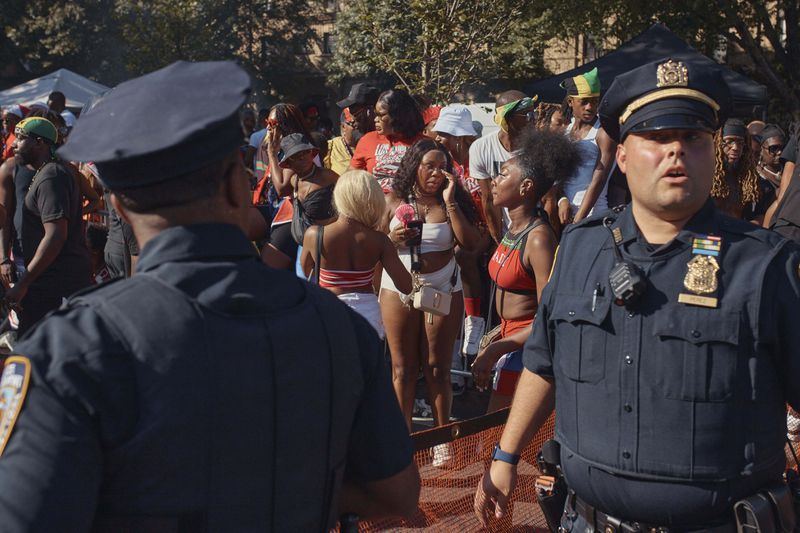 Police move revelers from the street after a shooting on Eastern Parkway, near the corner of Franklin Avenue, during the West Indian Day Parade on Monday, Sept. 2, 2024, in the Brooklyn borough of New York. (AP Photo/Andres Kudacki)