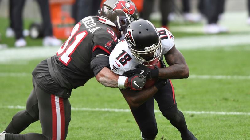 Mike Davis of the Atlanta Falcons is tackled by Antoine Winfield