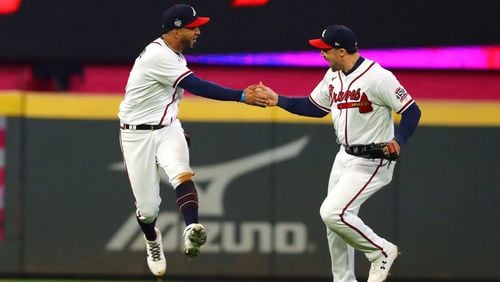 10/30/21 - Atlanta - Atlanta Braves left fielder Eddie Rosario, left, reacts after making a catch to get out Houston Astros second baseman Jose Altuve (not pictured) with center fielder Adam Duvall, right, to end the top of the eighth inning in game 4 in the World Series at Truist Park, Saturday October 30, 2021, in Atlanta. Curtis Compton / curtis.compton@ajc.com