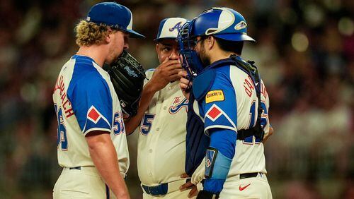 Atlanta Braves pitcher Spencer Schwellenbach (56) speaks with bullpen coach Erick Abreu (85) and catcher Travis d'Arnaud (16) on the mound in the fourth inning of a baseball game against the Toronto Blue Jays, Saturday, Sept. 7, 2024, in Atlanta.(AP Photo/Mike Stewart)