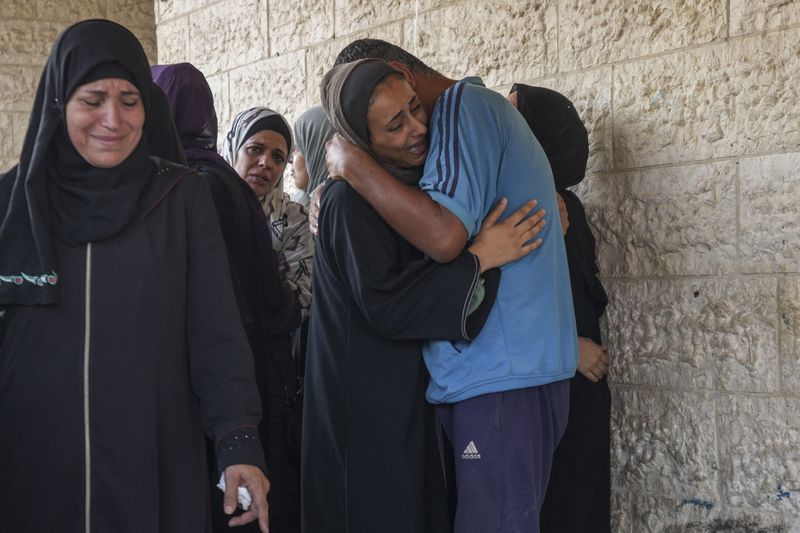 Palestinians grieve at the funeral for more than 15 people, including several children and women, killed in an Israeli strike, at Al-Aqsa Martyrs Hospital in Deir al-Balah, Gaza Strip, Saturday, Aug. 17, 2024. The strike hit a house and an adjacent warehouse sheltering displaced people at the entrance of the town of Zawaida, according to the hospital where the casualties were taken. (AP Photo/Abdel Kareem Hana)