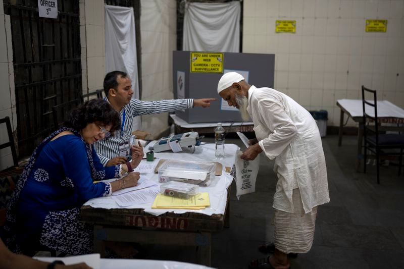 A Muslim voter is directed by a polling official as he registers to cast his vote in the sixth round of polling in India's national election in New Delhi, India, Saturday, May 25, 2024. (AP Photo/Altaf Qadri)