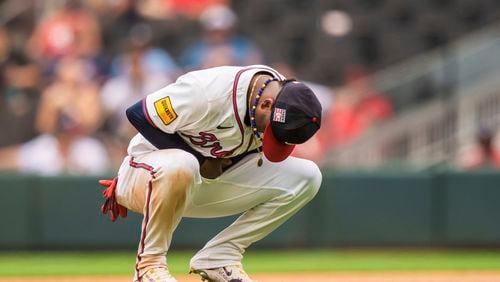 Atlanta Braves second baseman Ozzie Albies holds his wrist after an injury in the eighth inning of a baseball game against the St. Louis Cardinals, Sunday, July 21, 2024, in Atlanta. (AP Photo/Jason Allen)