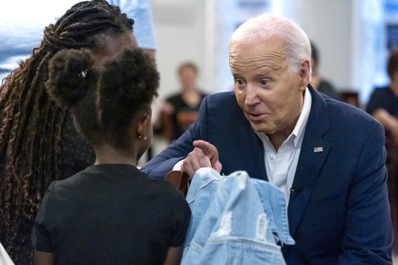 President Joe Biden, right, greets a young girl as he speaks with supporters at Mary Mac's Tea Room, Saturday, May 18, 2024, in Atlanta. (AP Photo/Alex Brandon)