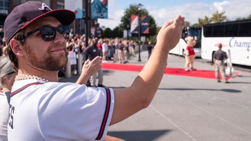 William Rossman of Marietta cheers the Braves with a tomahawk chop as they leave Truist Park on their way to Houston for the World Series on Monday afternoon, October 25, 2021. Ben Gray for the Atlanta Journal-Constitution