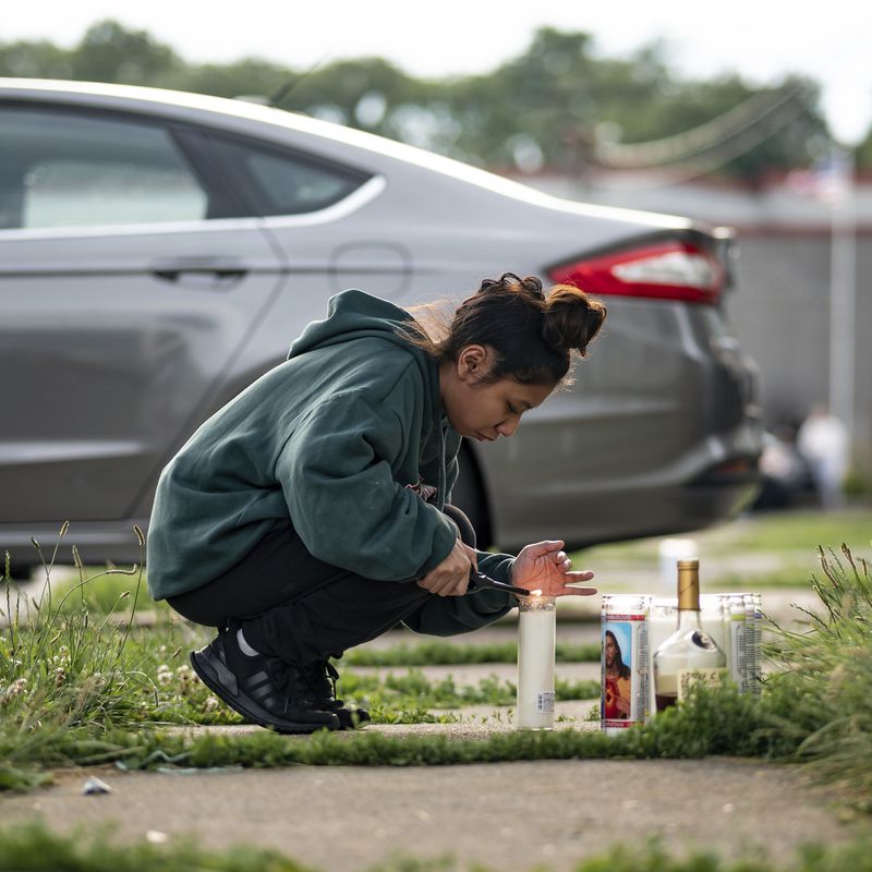 A young girl lights a candle during a vigil for 13-year-old Nyah Mway in Utica, N.Y., Saturday, June 29, 2024. On Friday, June 28, Mway was fatally shot by police who’d tackled him to the ground after he allegedly pointed what turned out to be a BB gun at them during a foot chase. (Daniel DeLoach/Observer-Dispatch via AP)
