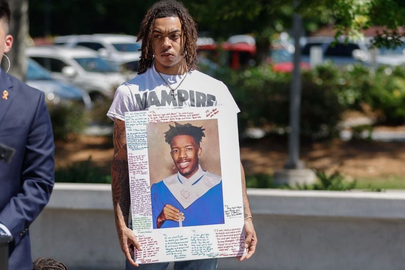 Kendan Shuff holds a photo of his childhood friend Timothy 'TJ' Henderson during a National Gun Violence Awareness Day event hosted by youth activist Tyler Lee at Gwinnett County Justice and Administration Center on Friday, June 7, 2024. Henderson was fatally shot outside of his home in Gwinnett in May. (Natrice Miller/ AJC)