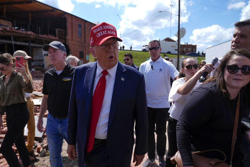 Former President Donald Trump walks outside the Chez What furniture store in Valdosta on Monday.